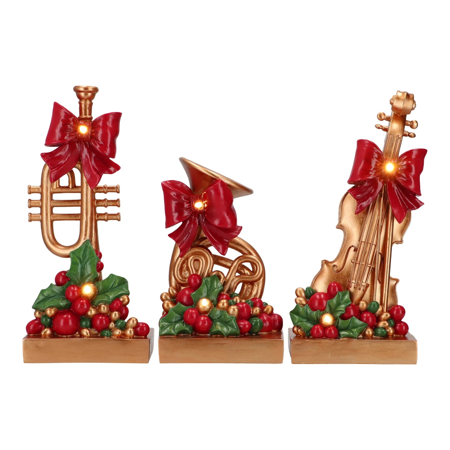 Golden Christmas musical instrument figurines — trumpet, French horn and violin — with red bows and illuminated holly decoration.