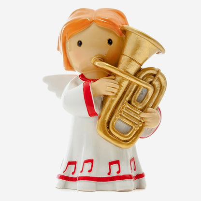 Figurine of an angel playing a tuba on a white background
