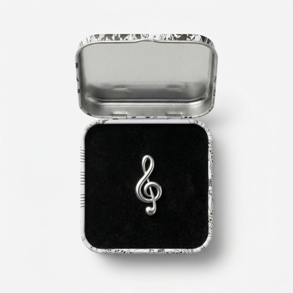 Close-up of treble clef metal lapel pin showing clean musical symbol