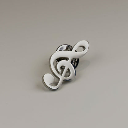 White treble clef brooch on a gray background