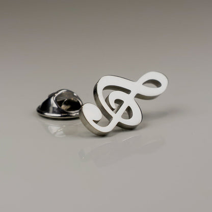 Metallic music symbol pin on a gray background