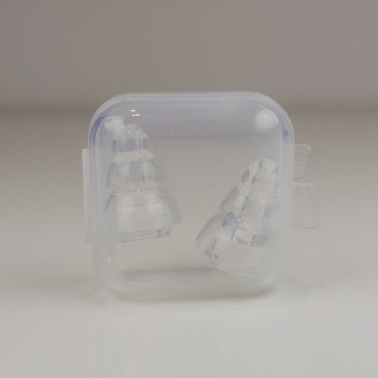 Clear plastic container with two white objects inside on a light gray background