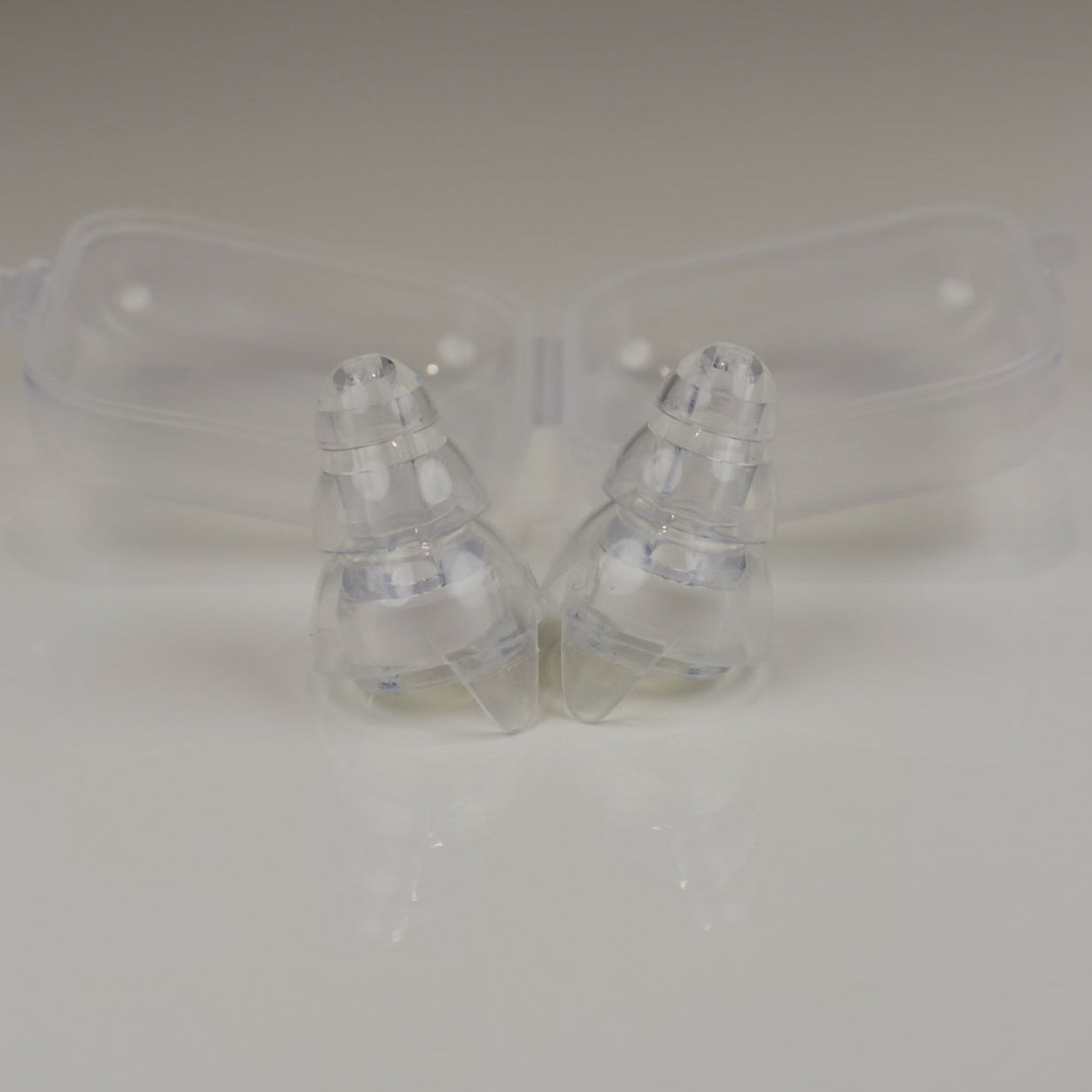 Clear plastic earbud cases on a light gray background