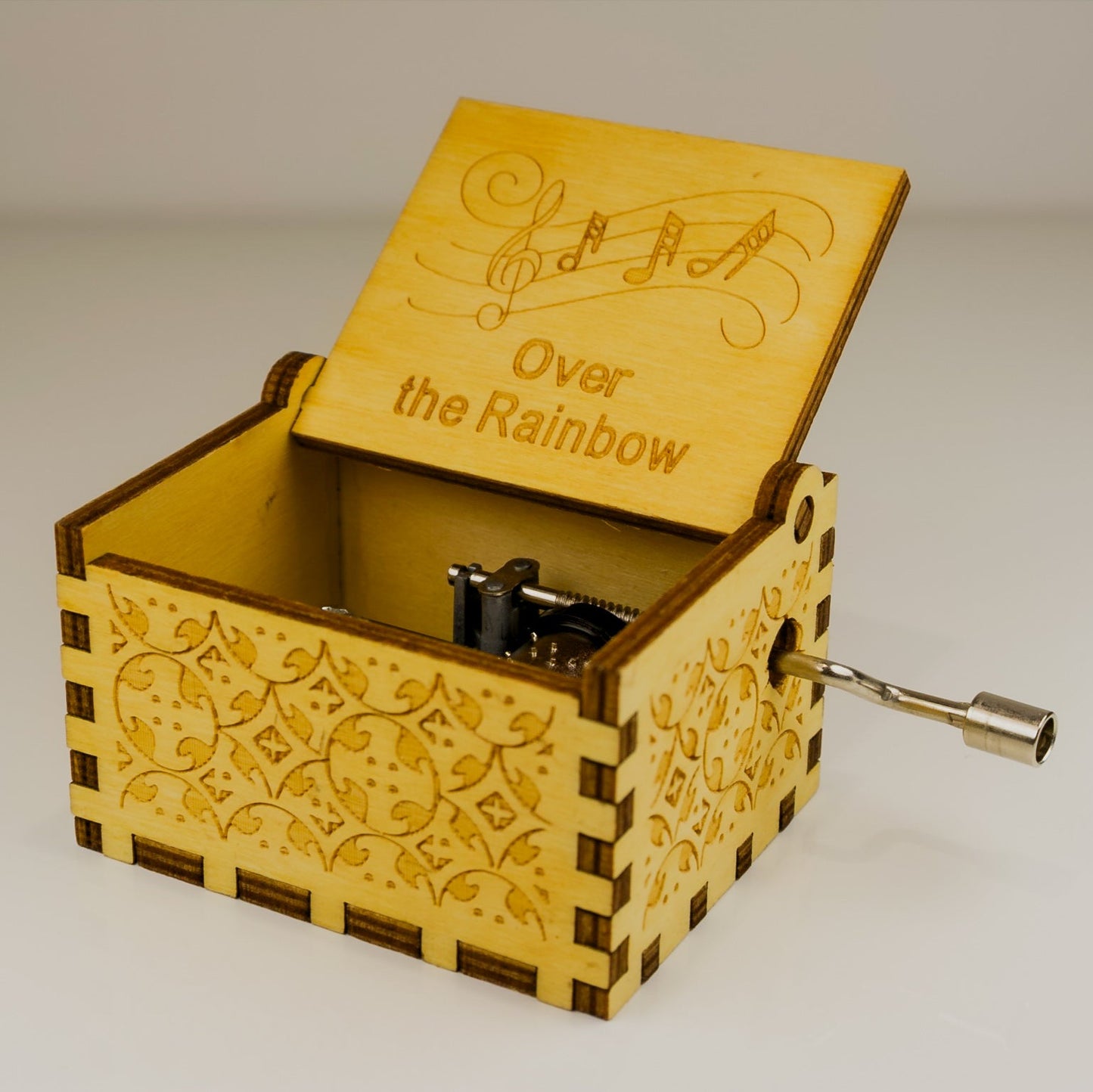 Wooden music box with 'Over the Rainbow' engraving on a plain background