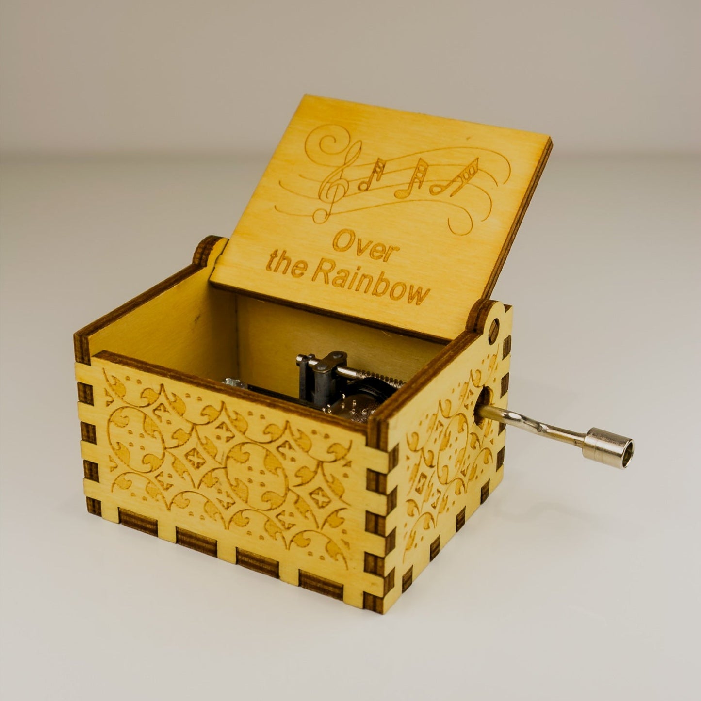 Wooden music box with 'Over the Rainbow' engraving on a plain background