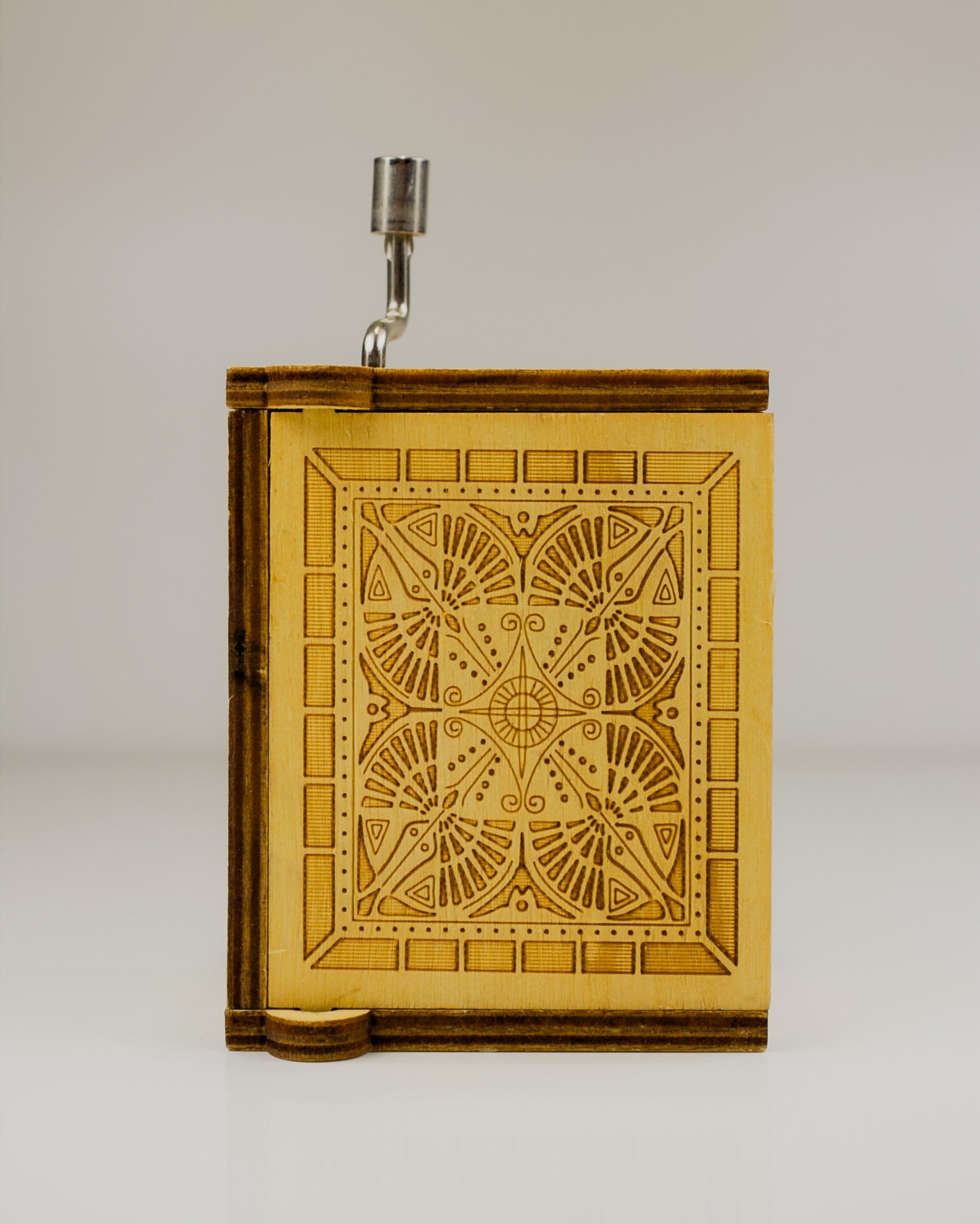 Wooden book-shaped lamp with geometric design on a white background