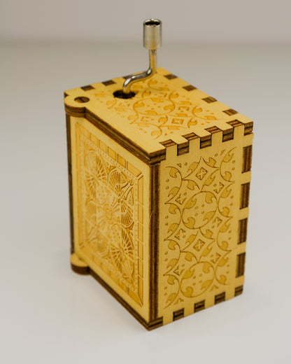 Wooden music box with intricate laser-cut designs on a plain background