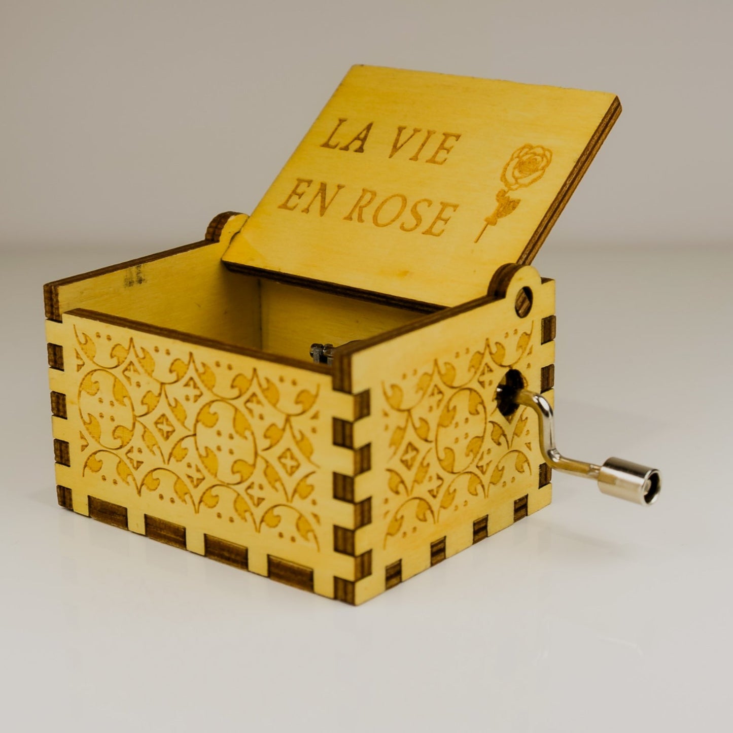 Wooden music box with 'La Vie En Rose' engraving on a white background