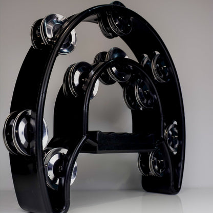 Black tambourine with silver jingles on a gray background
