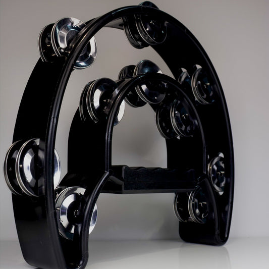 Black tambourine with silver jingles on a gray background
